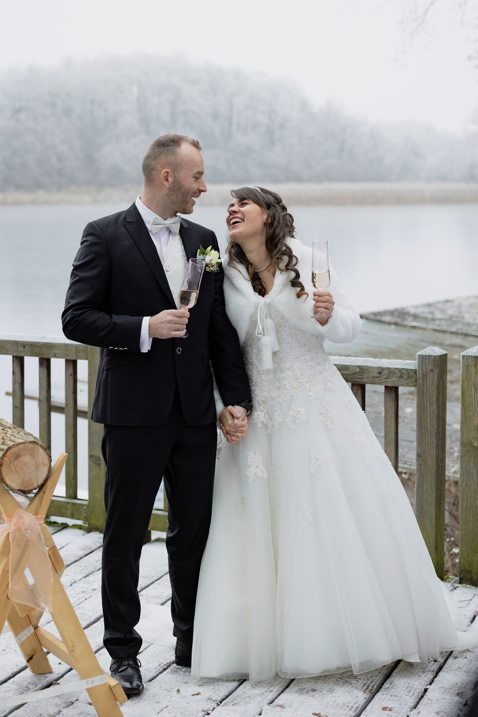 Winterhochzeit am See Berlin mit Brautpaar beim Sekt Empfang am Bötzsee 