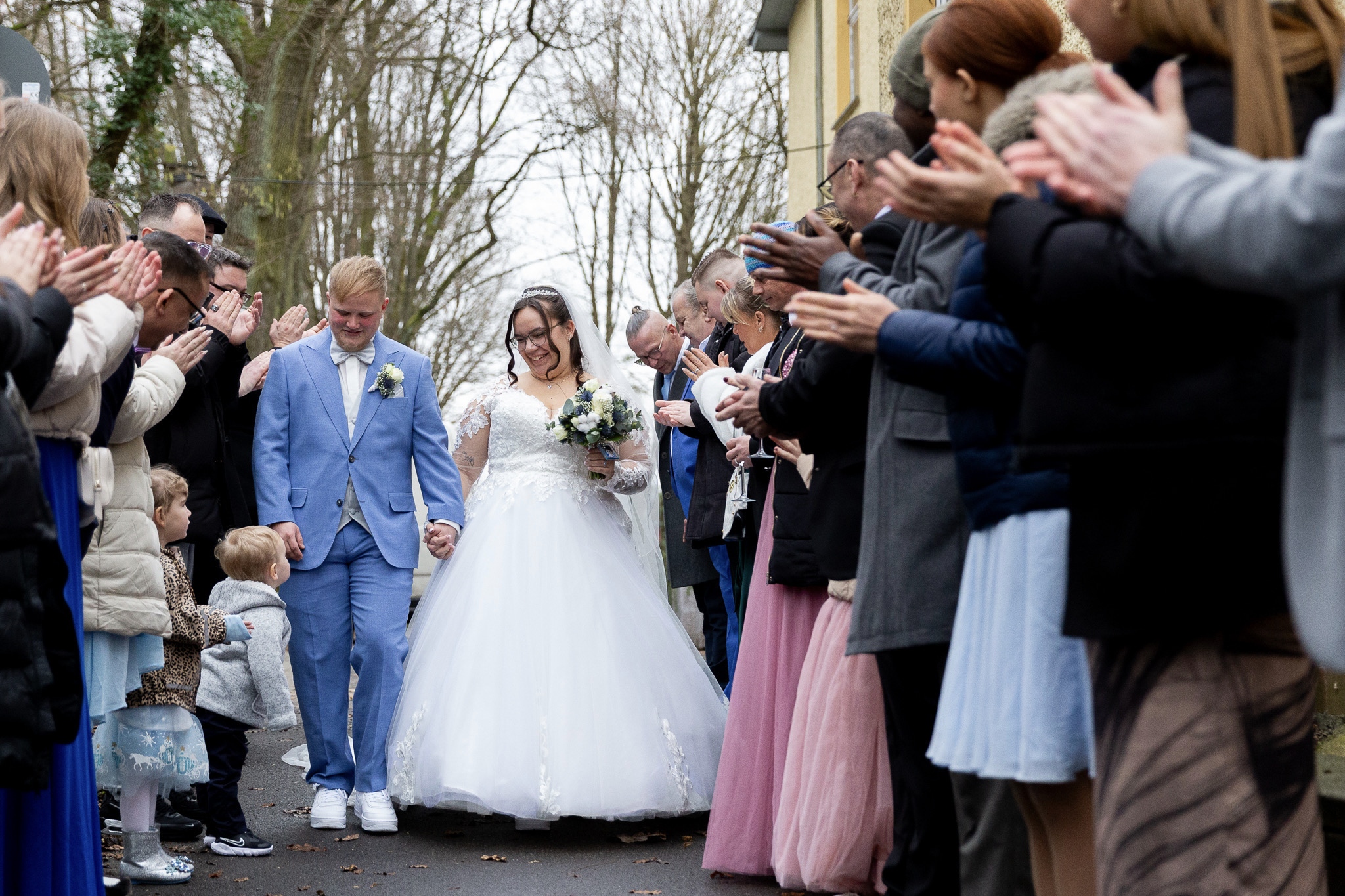 Winterhochzeit von Patricia und Dennis Seeschloss Brautpaar verlässt die Zeremonie glücklich.Die Gäste stehen Spalier. Winterhochzeit Seeschloss.