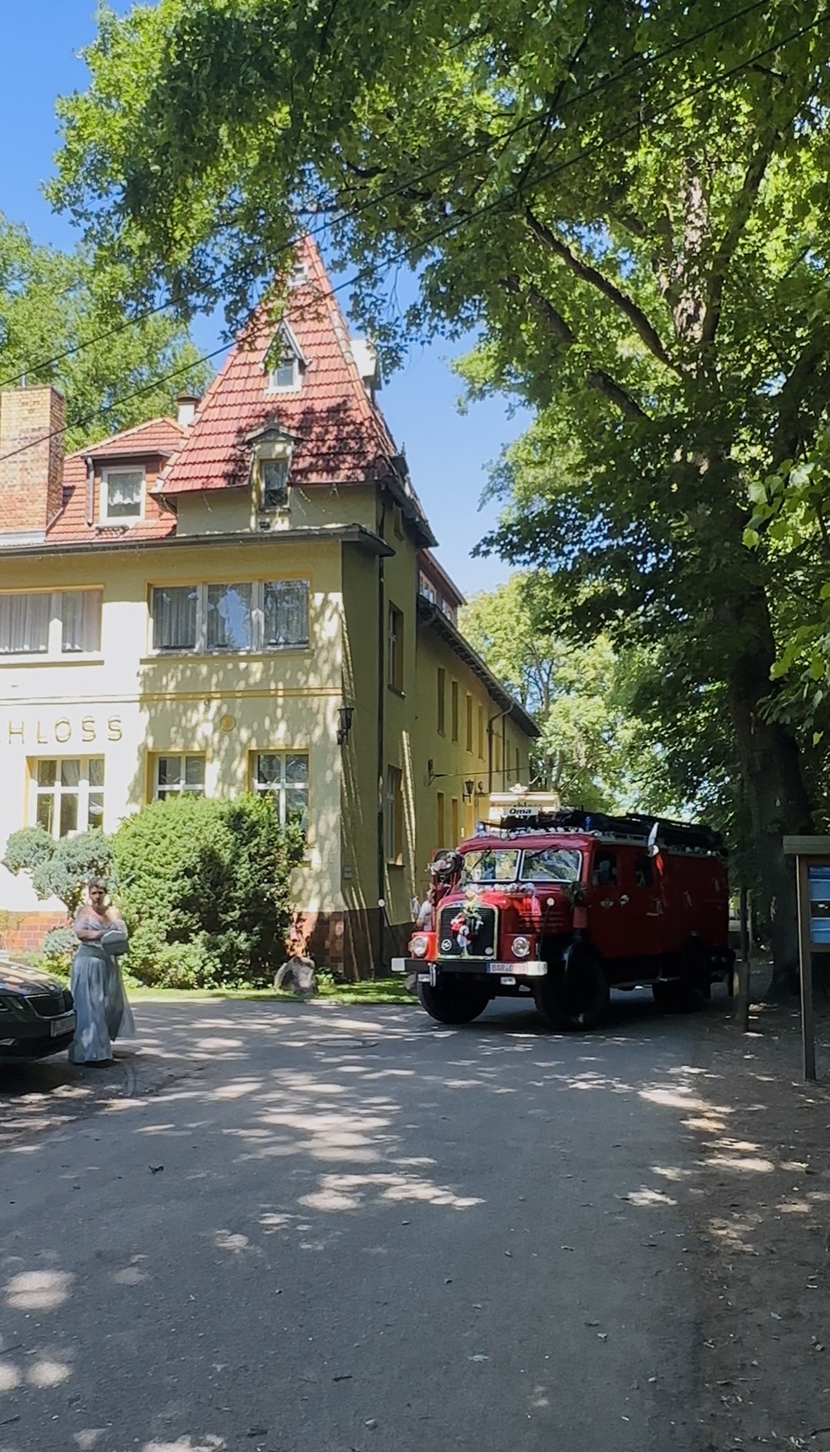 Nach der Trauung unter den Bäumen . Historische rote Feuerwehr vor dem Hotel Seeschloss am Bötzsee. Das restaurierte Fahrzeug wurde nach der Trauung für eine Rundfahrt durch Petershagen-Eggersdorf und als beliebter Foto-Hotspot für das Brautpaar und die Hochzeitsgäste.
