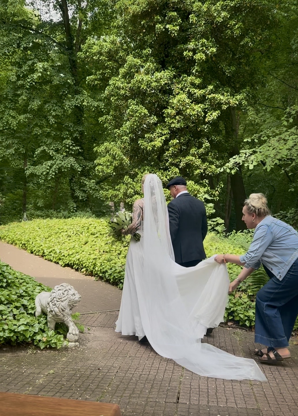 Braut wird von ihrem Vater zur standesamtlichen Trauung im Garten des Seeschlosses begleitet Braut wird von ihrem Vater zur standesamtlichen Trauung im Garten des Seeschlosses begleitet