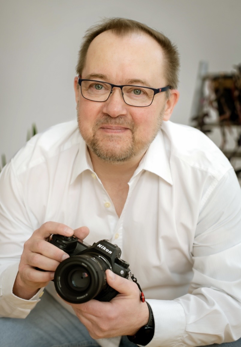 Fotograf Jansen Fotograf Jansen, Mann mit Kamera, lächelnd, freundlich.
